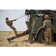 Un soldat détend le treuil de la grue d'un porteur polyvalent lourd de dépannage (PPLD) au terme d'un dépannage près d'Ayorou, au Niger.