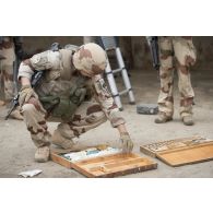 Un sapeur du 2e régiment étranger de génie (REG) examine des indices trouvés lors de la fouille d'un garage par l'armée malienne à Tombouctou, au Mali.