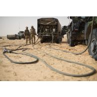 Des soldats du 503e régiment du train (RT) ravitaillent des véhicules de l'avant blindés (VAB) en carburant au moyen d'un camion-citerne polyvalent de 10m3 (CCP10) dans le secteur des monts Farach, au Mali.