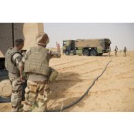 Des soldats du 503e régiment du train (RT) ravitaillent un véhicule blindé hautement protégé (VBHP) Aravis en carburant au moyen d'un camion-citerne polyvalent de 10m3 (CCP10) dans le secteur des monts Farach, au Mali.