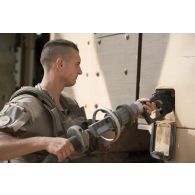 Un sapeur du 2e régiment étranger de génie (REG) ravitaille son véhicule blindé hautement protégé (VBHP) Aravis en carburant dans le secteur des monts Farach, au Mali.