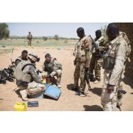 Des soldats du 2e régiment étranger de génie (REG) fouillent une malle découverte dans un village des monts Farach, au Mali.