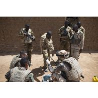 Des soldats du 2e régiment étranger de génie (REG) fouillent une malle découverte dans un village des monts Farach, au Mali.
