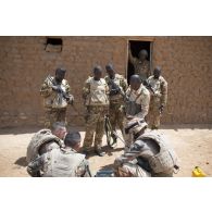 Des soldats du 2e régiment étranger de génie (REG) fouillent une malle découverte dans un village des monts Farach, au Mali.
