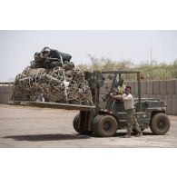 Un soldat américain de l'US Air Force guide le conducteur d'un chariot Valmet du détachement de transit interarmées (DéTIA) pour le chargement de fret à Gao, au Mali.