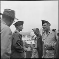 Le lieutenant-colonel Louvet, commandant le GM 7 (groupe mobile) et le lieutenant-colonel Multrier en conversation avec le général Cogny, commandant des FTVN (Forces terrestres du Nord-Vietnam), en bordure de la piste d'aviation du camp retranché de Na San, en cours d'évacuation.