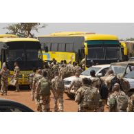 Des soldats chargent leurs effets personnels à bord d'un autocar pour leur départ de Niamey, au Niger.