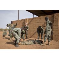 Un instructeur des éléments français au Sénégal (EFS) encadre des soldats maliens de la 132e compagnie d'infanterie motorisée (CIM) pour un atelier de relève de blessé sous le feu à Gao, au Mali.