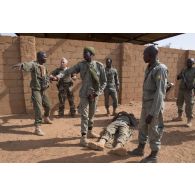 Un instructeur des éléments français au Sénégal (EFS) encadre des soldats maliens de la 132e compagnie d'infanterie motorisée (CIM) pour un atelier de relève de blessé sous le feu à Gao, au Mali.