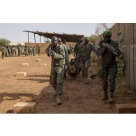 Des soldats maliens de la 132e compagnie d'infanterie motorisée (CIM) participent à un atelier de relève de blessé sous le feu à Gao, au Mali.