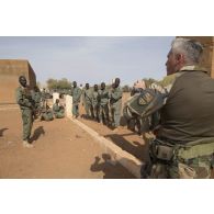 Un instructeur des éléments français au Sénégal (EFS) encadre des soldats maliens de la 132e compagnie d'infanterie motorisée (CIM) pour un atelier de relève de blessé sous le feu à Gao, au Mali.