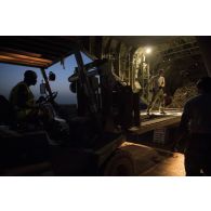 Des soldats du détachement de transit interarmées (DéTIA) déchargent du fret depuis la tranche arrière d'un avion Hercules C-130J-30 de l'US Air Force sur l'aérodrome de Gao, au Mali.