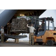 Le détachement de transit interarmées (DéTIA) charge du fret à bord d'un avion Hercules C130-J30 de l'US Air Force à Niamey, au Niger.