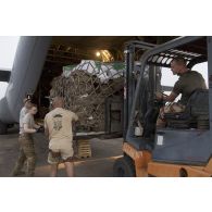 Le détachement de transit interarmées (DéTIA) charge du fret à bord d'un avion Hercules C130-J30 de l'US Air Force à Niamey, au Niger.