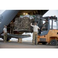 Le détachement de transit interarmées (DéTIA) charge du fret à bord d'un avion Hercules C130-J30 de l'US Air Force à Niamey, au Niger.