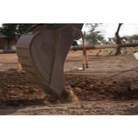 Une pelle hydraulique 317 du 25e régiment du génie de l'air (RGA) terrasse le sol à Niamey, au Niger.