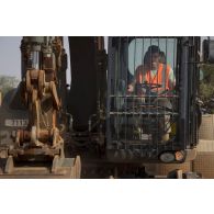 Un sapeur du 25e régiment du génie de l'air (RGA) pilote une pelle hydraulique 317 pour le terrassement du sol à Niamey, au Niger.