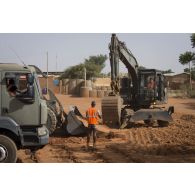 Une pelle hydraulique 317 du 25e régiment du génie de l'air (RGA) terrasse le sol à Niamey, au Niger.
