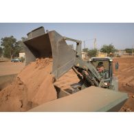 Une pelle hydraulique 317 du 25e régiment du génie de l'air (RGA) terrasse le sol à Niamey, au Niger.