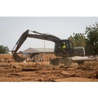 Une pelle hydraulique 317 du 25e régiment du génie de l'air (RGA) terrasse le sol à Niamey, au Niger.