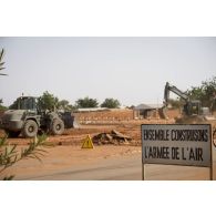 Une pelle hydraulique 317 et une niveleuse F 106.7 du 25e régiment du génie de l'air (RGA) terrassent le sol à Niamey, au Niger.