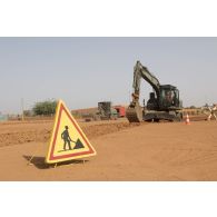 Une pelle hydraulique 317 et une niveleuse F 106.7 du 25e régiment du génie de l'air (RGA) terrassent le sol à Niamey, au Niger.