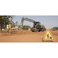 Une pelle hydraulique 317 et une niveleuse F 106.7 du 25e régiment du génie de l'air (RGA) terrassent le sol à Niamey, au Niger.