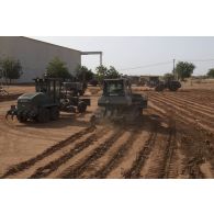 Une pelle hydraulique 317, une  niveleuse F 106.7, une chargeuse-pelleteuse Terex TL 210 et bulldozer lourd PR724 du 25e régiment du génie de l'air (RGA) terrassent le sol à Niamey, au Niger.