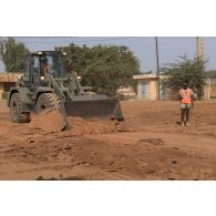 Une chargeuse-pelleteuse Terex TL 210 du 25e régiment du génie de l'air (RGA) terrase le sol à Niamey, au Niger.