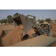Une chargeuse-pelleteuse Terex TL 210 du 25e régiment du génie de l'air (RGA) terrase le sol à Niamey, au Niger.