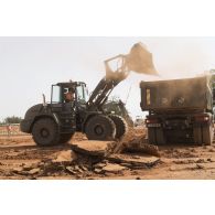 Une chargeuse-pelleteuse Terex TL 210 du 25e régiment du génie de l'air (RGA) terrase le sol à Niamey, au Niger.