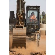Un sapeur du 25e régiment du génie de l'air (RGA) pilote une pelle hydraulique 317 pour le terrassement du sol à Niamey, au Niger.
