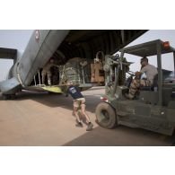Des soldats du détachement de transit interarmées (DéTIA) chargent du fret à bord d'un avion Transall C-160 pour une opération de largage à Niamey, au Niger.