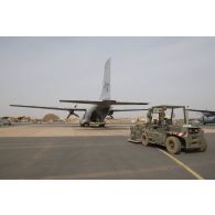 Des soldats du détachement de transit interarmées (DéTIA) chargent du fret à bord d'un avion Transall C-160 pour une opération de largage à Niamey, au Niger.