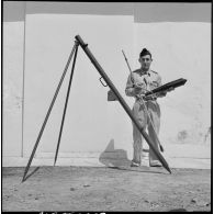 Un soldat présentant une fusée éclairante et sa rampe de lancement.