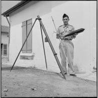 Un soldat présentant une fusée éclairante et sa rampe de lancement.