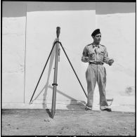 Un soldat présentant une fusée éclairante et sa rampe de lancement.