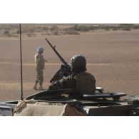 Un soldat de l'escadron Vert sécurise le périmètre au moyen de la mitrailleuse ANF1 de son véhicule blindé léger (VBL) dans la région d'Ansongo, au Mali.