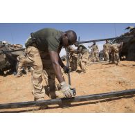 Des soldats montent la tente du poste de commandement tactique (PC TAC) sur une base opérationnelle avancée temporaire (BOAT) dans la région d'Ansongo, au Mali.
