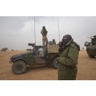 Le capitaine Klaus du 12e régiment de cuirassiers (RC) se coordonne avec son homologue malien pour le départ d'un convoi pour une mission dans la région d'Ansongo, au Mali.