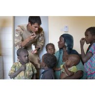 Le médecin des armées Victor explique les consignes de posologie d'un médicament à une mère de famille à Tin Hama, au Mali.