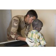 Le médecin des armées Victor ausculte un enfant à Tin Hama, au Mali.