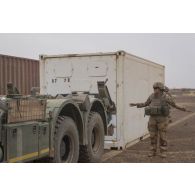 Un soldat guide le déchargement de palettes d'eau par container depuis un camion porteur polyvalent logistique (PPLOG) dans la région d'Ansongo, au Mali.