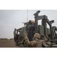 Un soldat guide le déchargement de palettes d'eau par container depuis un camion porteur polyvalent logistique (PPLOG) dans la région d'Ansongo, au Mali.