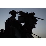 Un soldat sécurise le périmètre au moyen d'ue mitrailleuse Browning M2 de 12,7 mm en tourelle d'un véhicule de l'avant blindé (VABà dans la région de Bitagoungou, au Mali.