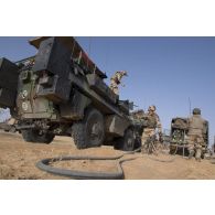 Des soldats du Service des essences des armées (SEA) ravitaillent un véhicule de l'avant blindé (VAB) en carburant au moyen d'un camion-citerne polyvalent de 10m3 (CCP 10m3) à Bitagoungou, au Mali.