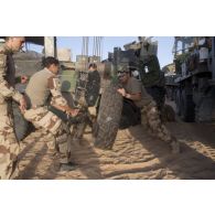 Des mécaniciens changent la roue d'un véhicule de l'avant blindé (VAB) ensablé au moyen du treuil d'un camion lourd de dépannage (CLD) dans la région de Bitagoungou, au Mali.