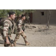 Le capitaine Clément du régiment de marche du Tchad (RMT) accompagné d'un agent des actions civilo-militaires (CIMIC) progresse dans les rues de Bitagoungou, au Mali.