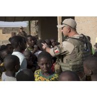 Un agent des actions civilo-militaires (CIMIC) s'entretient avec des enfants de Bitagoungou, au Mali.