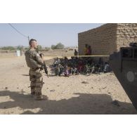 Un agent des actions civilo-militaires (CIMIC) prend contact avec des enfants dans les rues de Bitagoungou, au Mali.